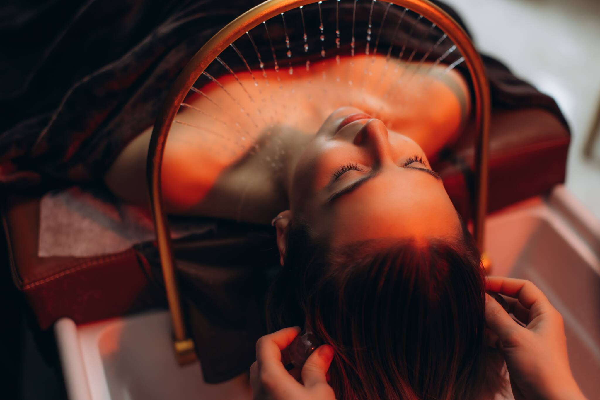 Woman enjoying hair massage treatment in spa salon